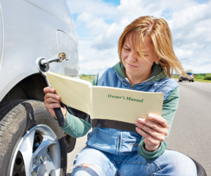 Woman reading owner’s manual while pulled over